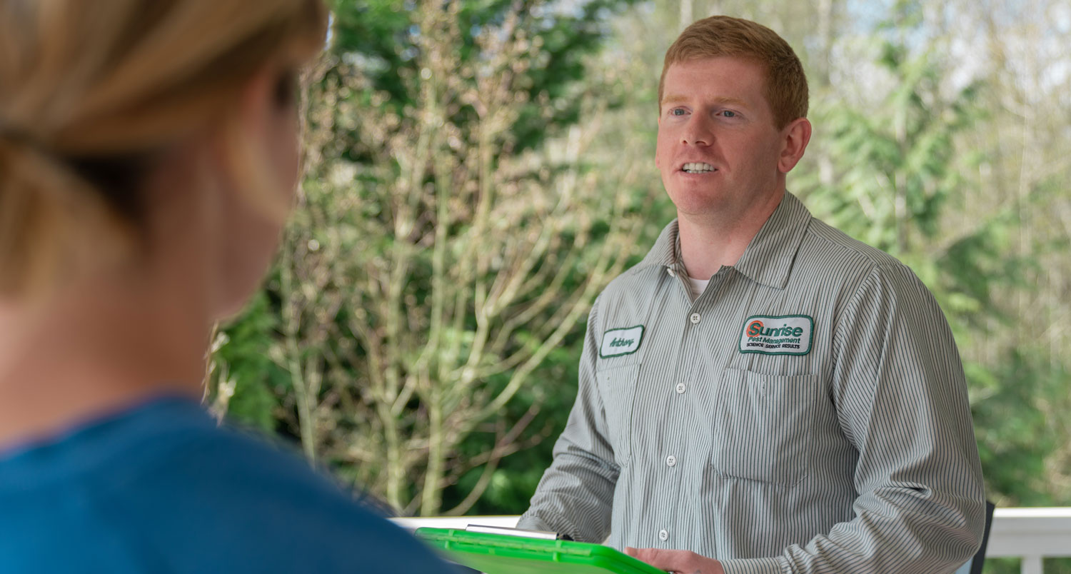 Sunrise Pest technician consulting with homeowner about carpet beetle control